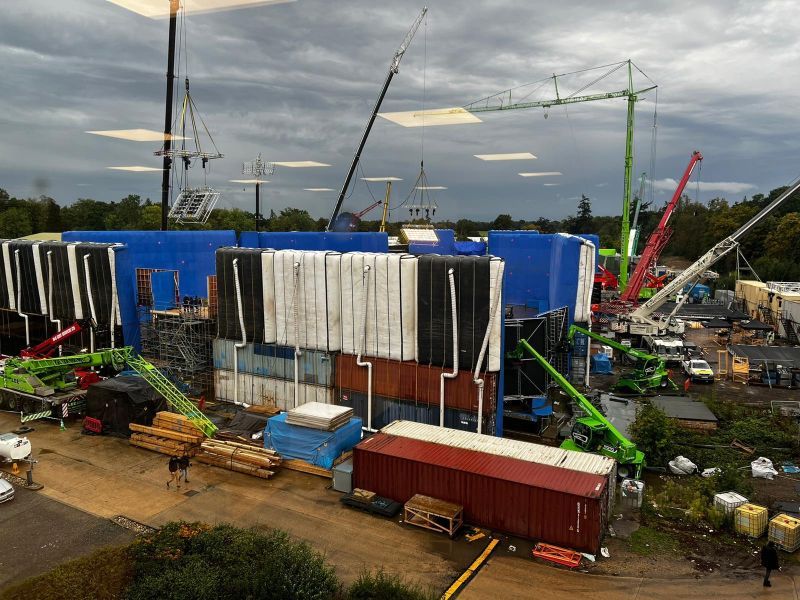 Blue AirWall surrounding a set at dusk with cranes and containers