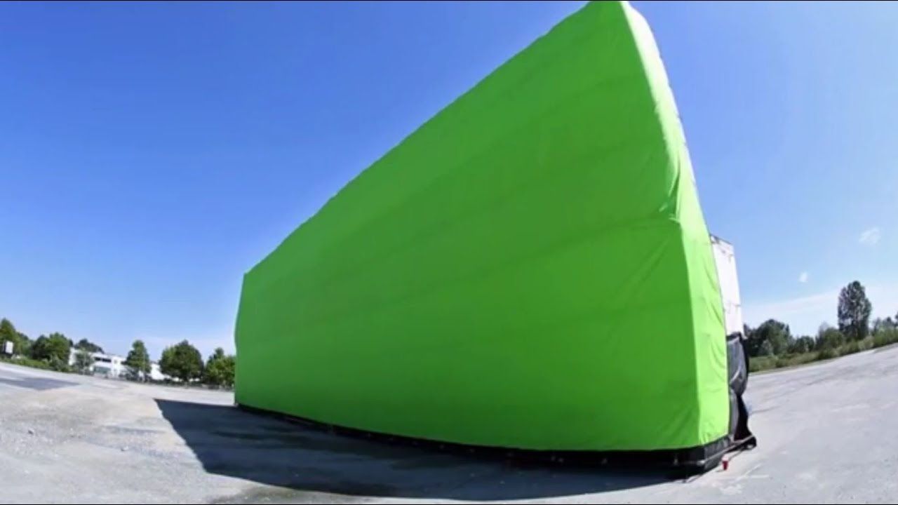 Green inflatable AirWall section against a blue sky