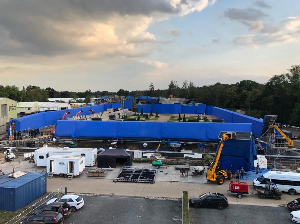 Blue AirWall sections around a backlot set at dusk with unit vehicles in front