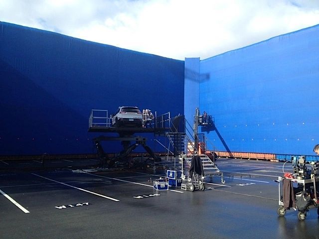 Waterproof blue Cinemattex screen behind a vehicle rig on a wet backlot